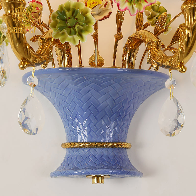 Macro detail of the hand-painted yellow and pink ceramic roses and green leaves on the creative wall sconce.