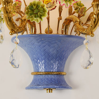 Macro detail of the hand-painted yellow and pink ceramic roses and green leaves on the creative wall sconce.