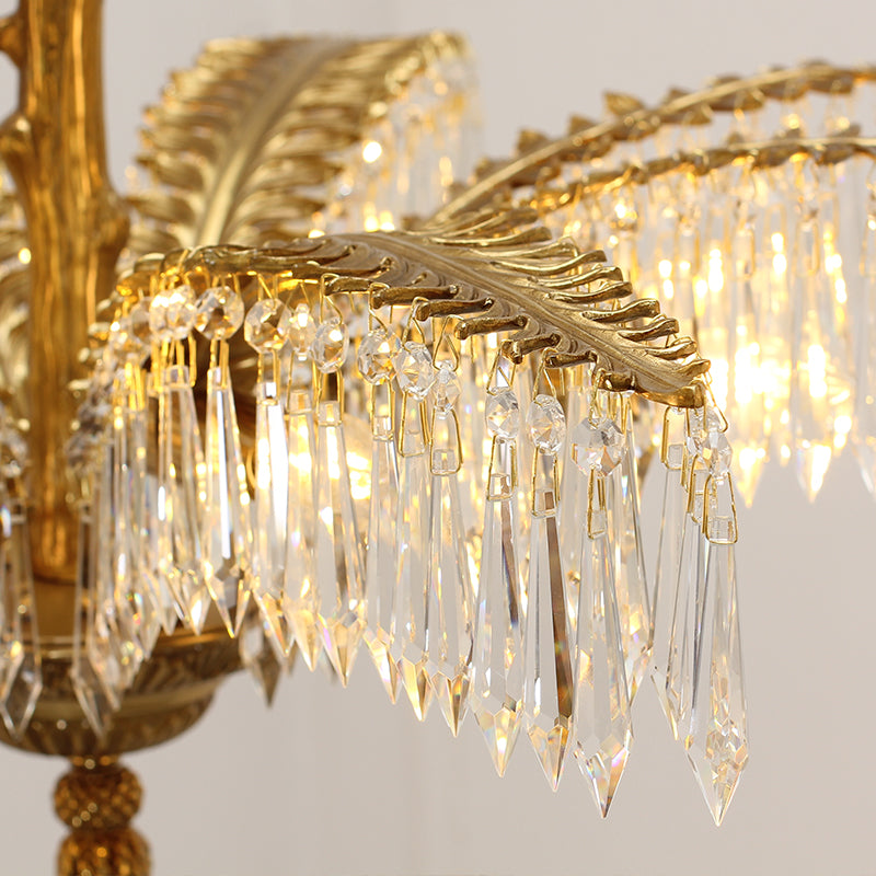 Extreme close-up of intricate crystal droplets and brass foliage on a decorative chandelier.