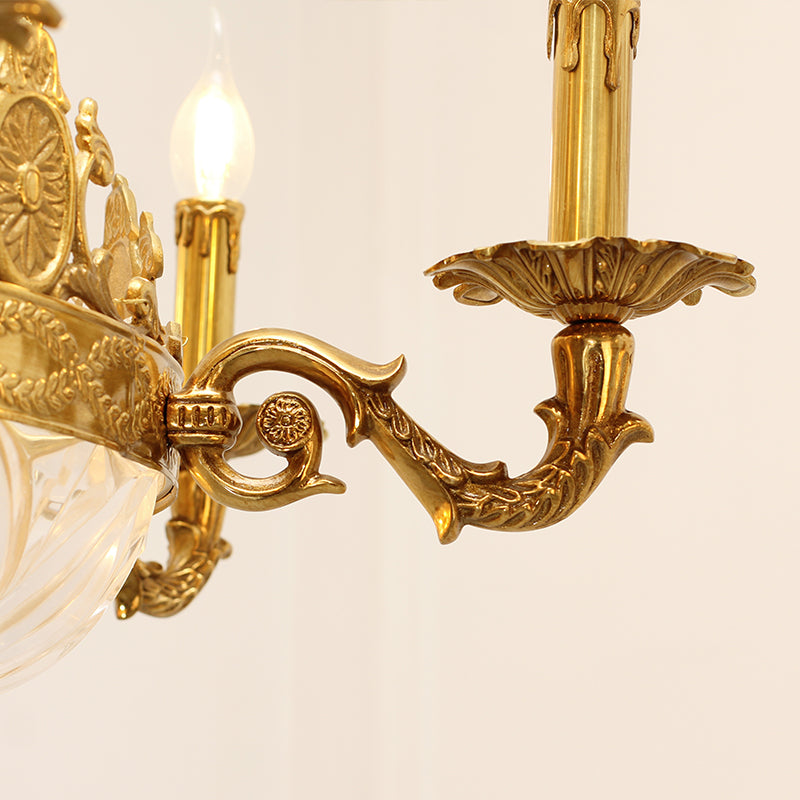 Close-up detail of a curved brass arm with intricate carvings, connecting to a crystal element.