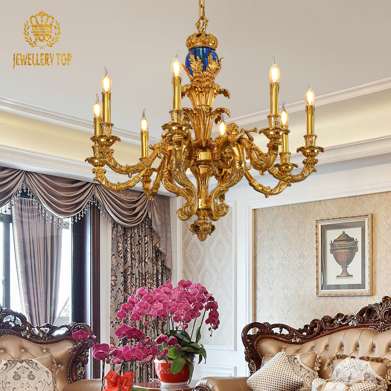 JEWELLERY TOP’s French brass chandelier lit in an elegant room with gray curtains and orchids.