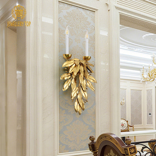 The vintage luxury brass wall lamp installed on a decorative blue and gold damask wallpaper, brand logo visible.