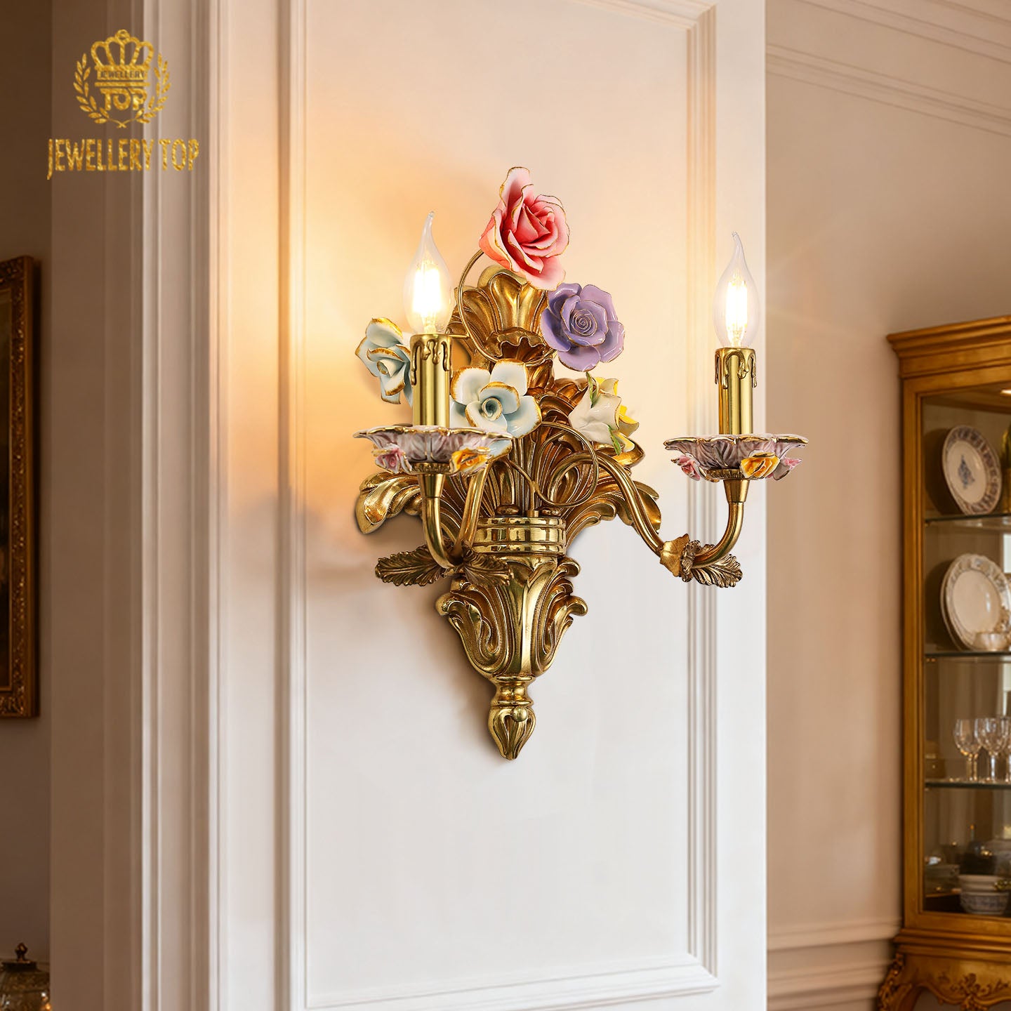 Detailed macro shot of a vibrant yellow ceramic rose with green leaves on the ornate golden brass arm of the sconce.