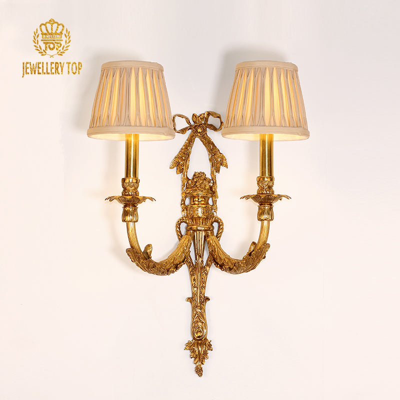 JEWELLERY TOP brand image of the luxury brass wall lamp installed on a white wall, showcasing its full elegant profile.