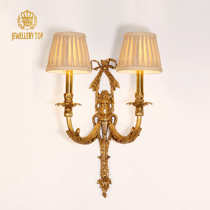 JEWELLERY TOP brand image of the luxury brass wall lamp installed on a white wall, showcasing its full elegant profile.