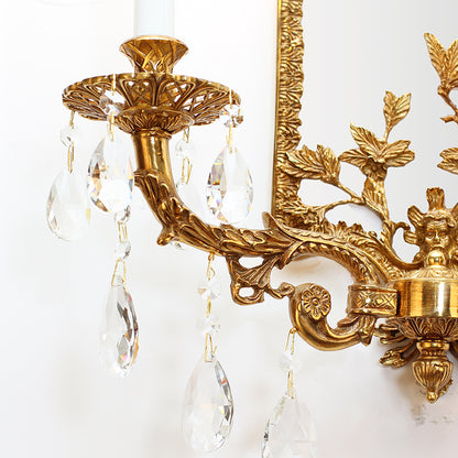 Close-up side view focusing on a single candle-style bulb and the hanging crystal droplet pendants of the wall light.