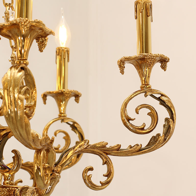 Macro shot of a single curved brass arm with leaf detailing and a flame-tip bulb.