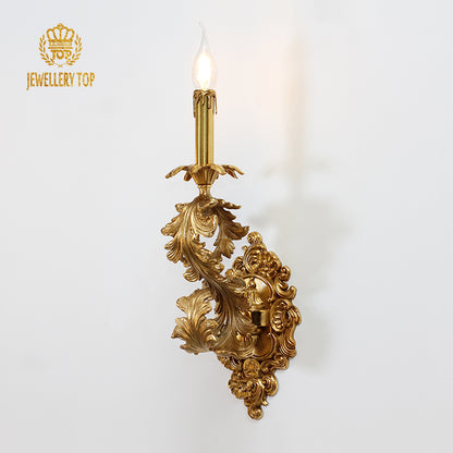 JEWELLERY TOP branded close-up of the ornate single-head candle wall light with glowing bulb.