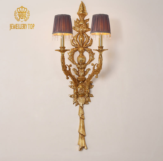JEWELLERY TOP branded French wall sconce with deep purple lampshades, ornate crest, and lit candle bulbs.