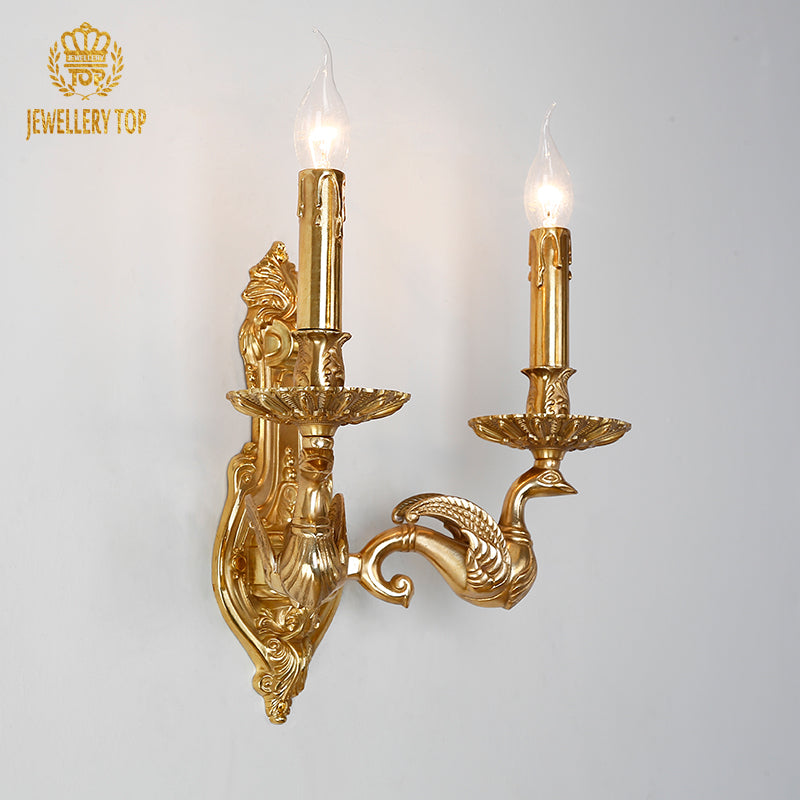 Close-up detail of the ornate brass wall lamp showcasing intricate scrollwork and candle-style bulbs.