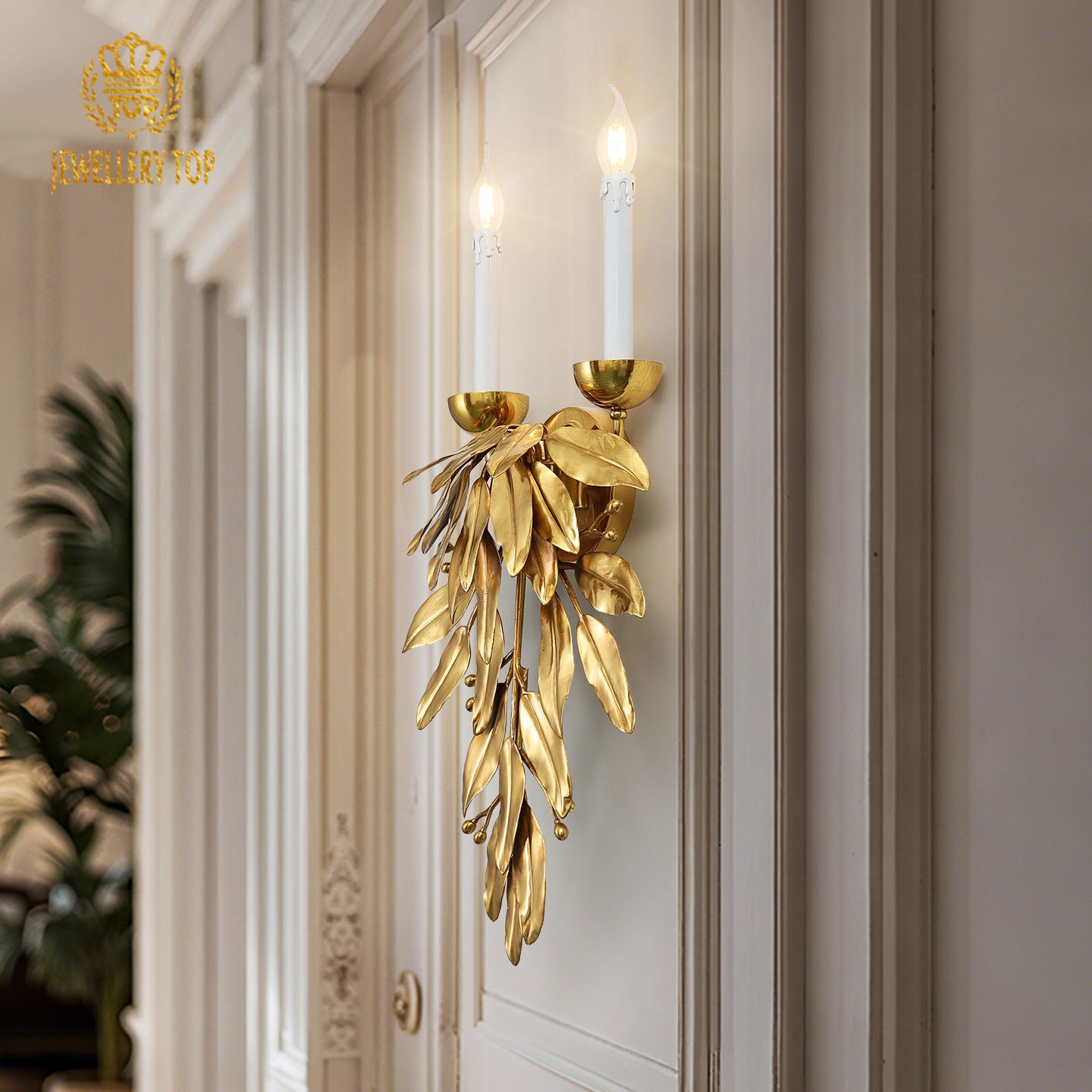 Detailed close-up of the French-style leaf wall light mounted on a white wall beside an ornate wooden door frame.