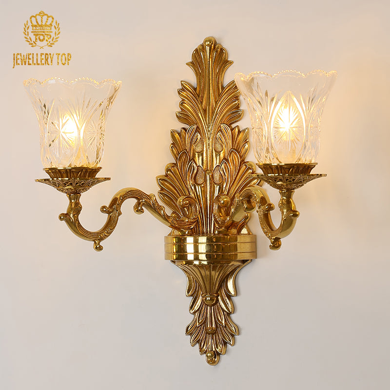 Branded product shot (JEWELLERY TOP) of the ornate double-head wall lamp with crystal-clear glass lampshades.