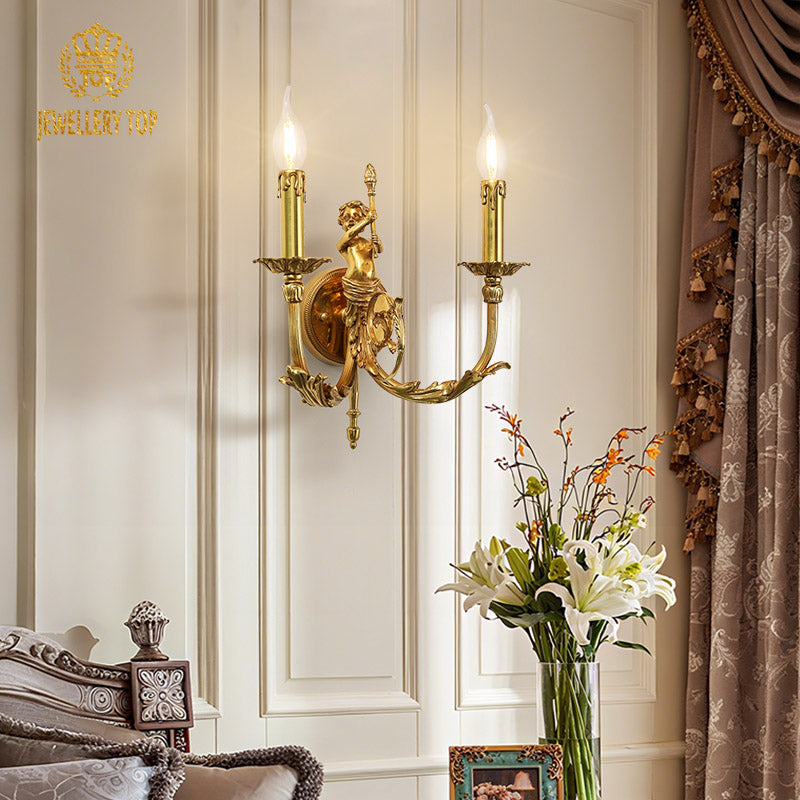 Detailed view of the brass sconce with an angel figurine, installed beside a bedside table with a vase of lilies.