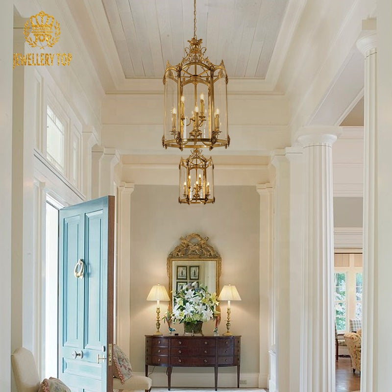 JEWELLERY TOP’s antique bronze pendant light in an elegant foyer with blue door and mirror.