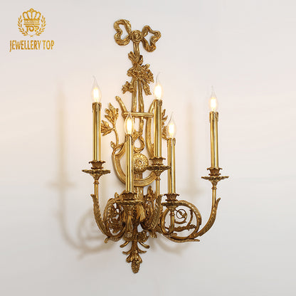 Front product view of the golden five-light brass candelabra sconce with intricate floral and leaf carvings.