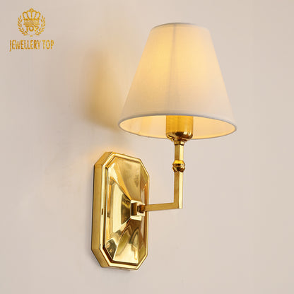 Octagon Noeud Brass Wall Lamp with white fabric shade installed on a light wall, brand JEWELLERY TOP visible.