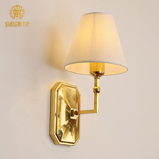 Octagon Noeud Brass Wall Lamp with white fabric shade installed on a light wall, brand JEWELLERY TOP visible.