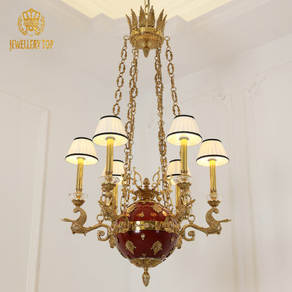 Front view of the JEWELLERY TOP brass chandelier with red center and white pleated shades.