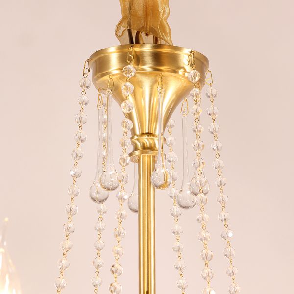 Macro close-up of the finely detailed brass arm and the dangling crystal teardrop pendants.