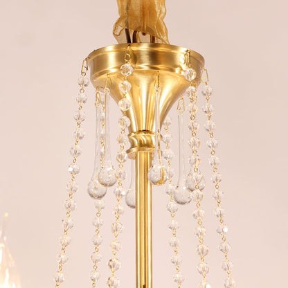 Macro close-up of the finely detailed brass arm and the dangling crystal teardrop pendants.