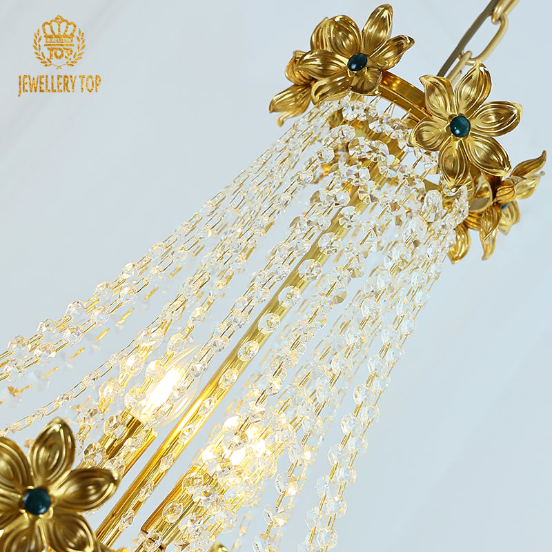 Macro close-up of the golden flower embellishments with their central teal gemstone accents.