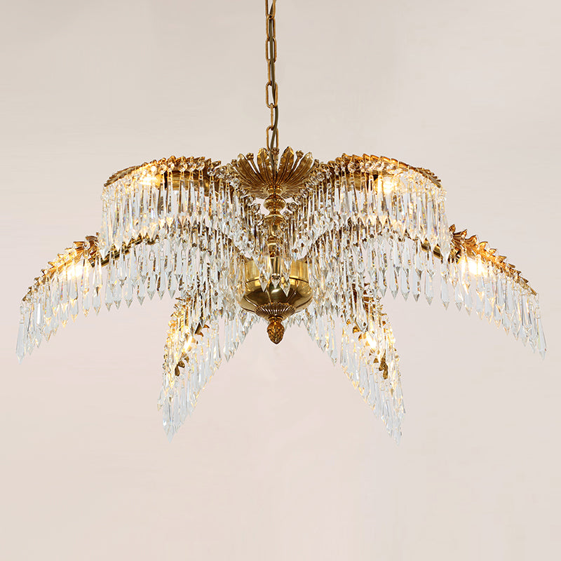 The crystal-adorned brass chandelier casting sparkling light patterns on a neutral wall.