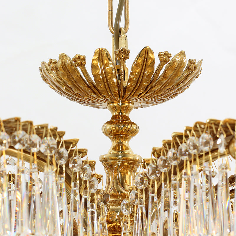 Detailed macro shot of a single engraved brass palm leaf and suspended crystal strings.