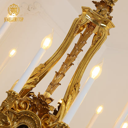 Close-up detail of the intricate leaf carvings and a candle bulb on a brass chandelier arm.