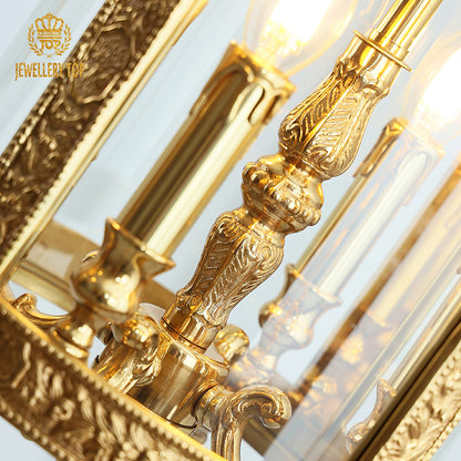 Extreme close-up of intricate brass scrollwork and a lit bulb on the luxury pendant light.