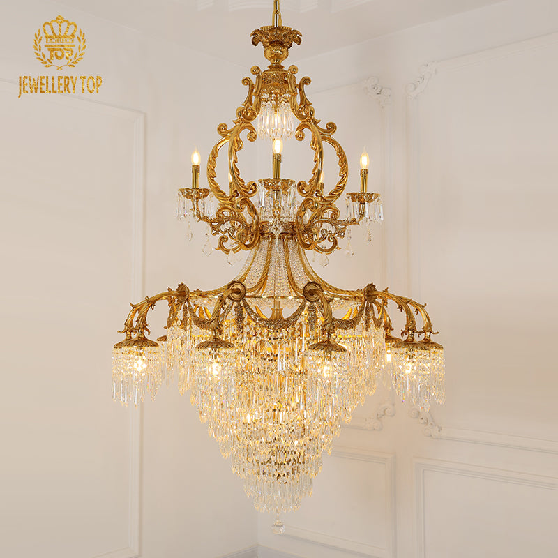 Ornate brass chandelier frame with hanging crystal prisms, brand JEWELLERY TOP visible.