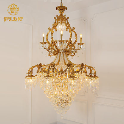 Ornate brass chandelier frame with hanging crystal prisms, brand JEWELLERY TOP visible.