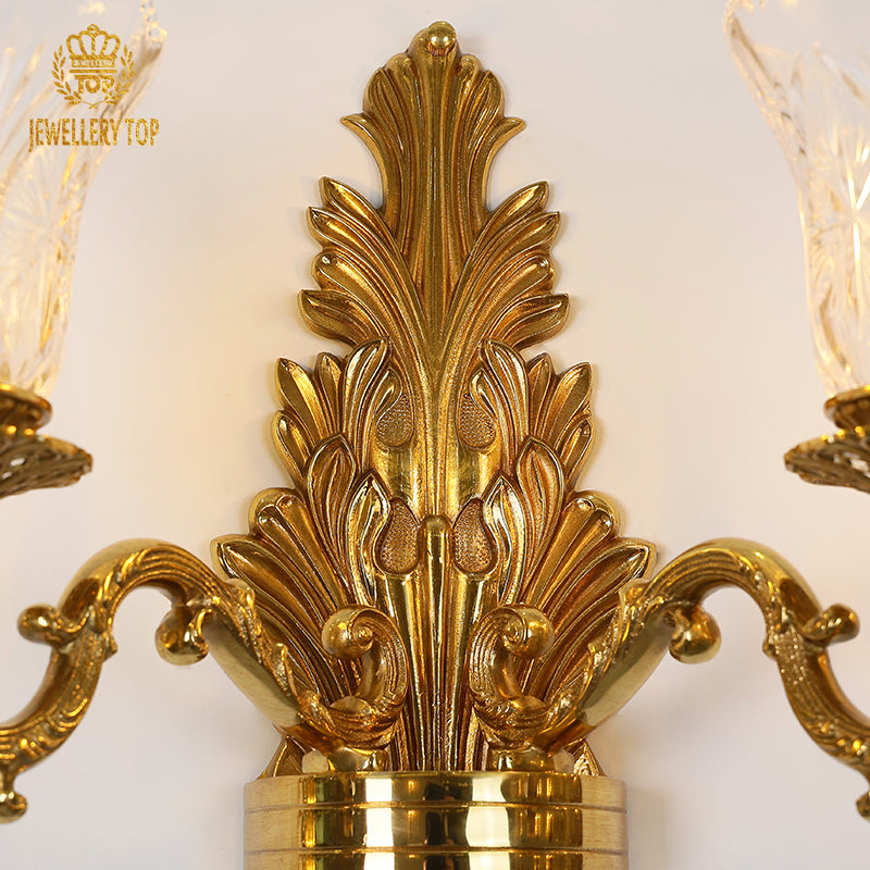 Close-up detail of the sconce’s intricate brass scrollwork, leaf motifs, and polished golden finish.