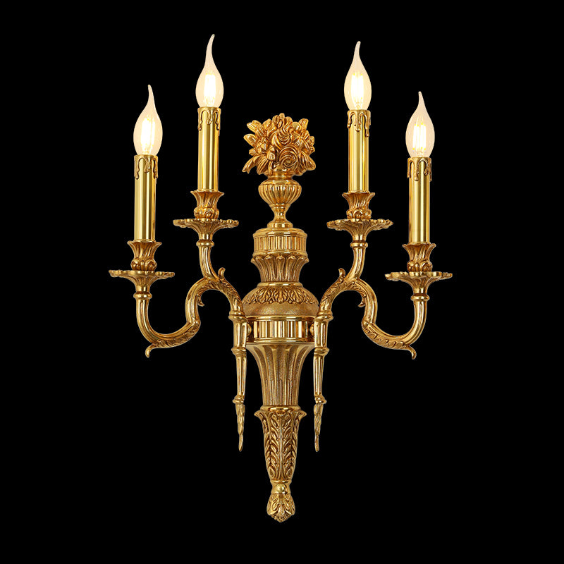 Triomphe Lys three-light golden brass wall sconce with ornate floral centerpiece, isolated on a black background.