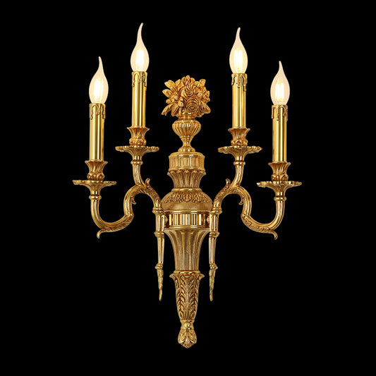 Triomphe Lys three-light golden brass wall sconce with ornate floral centerpiece, isolated on a black background.