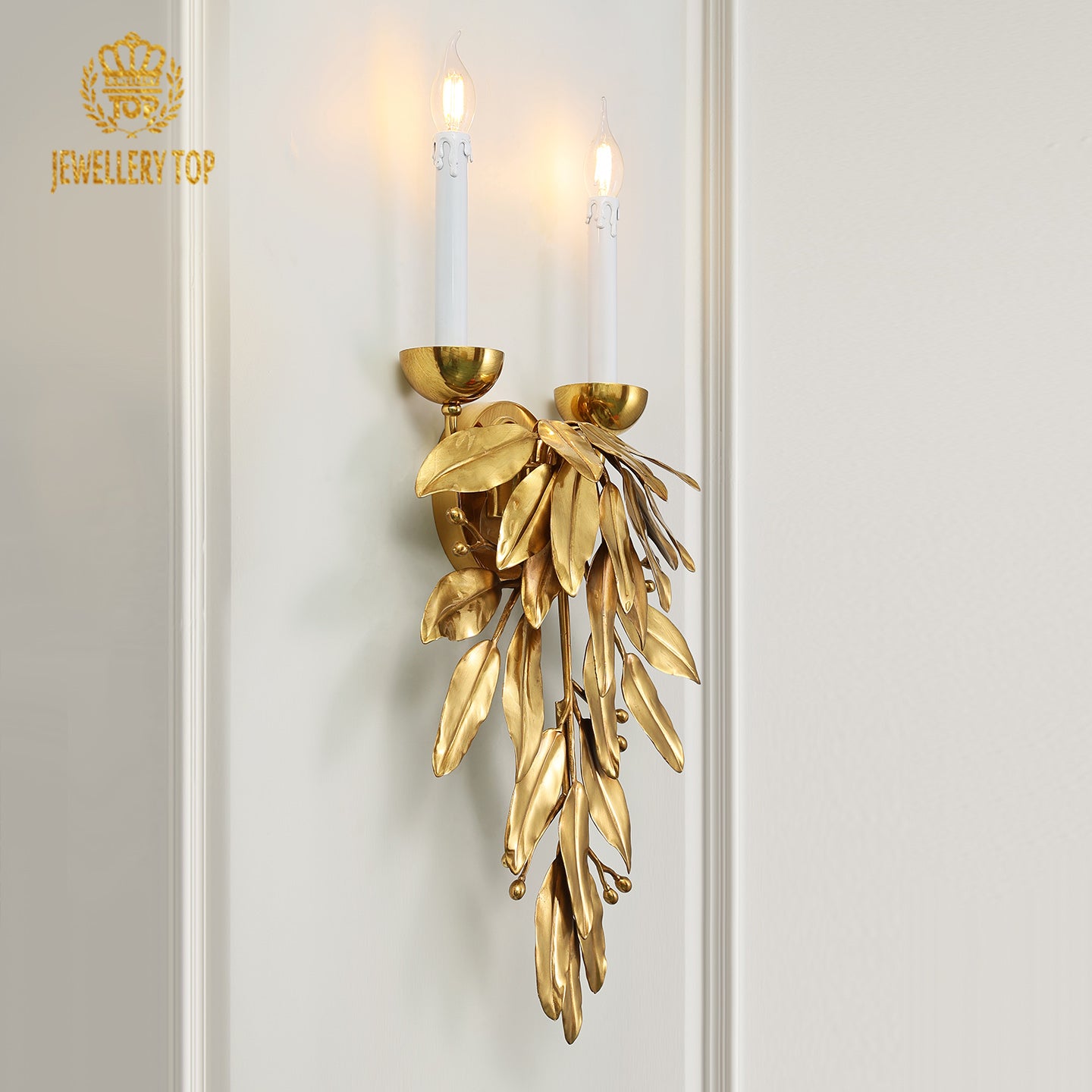 Front product view of the ornate brass sconce showcasing its pendant leaf cluster and classic candle-style bulb holders.