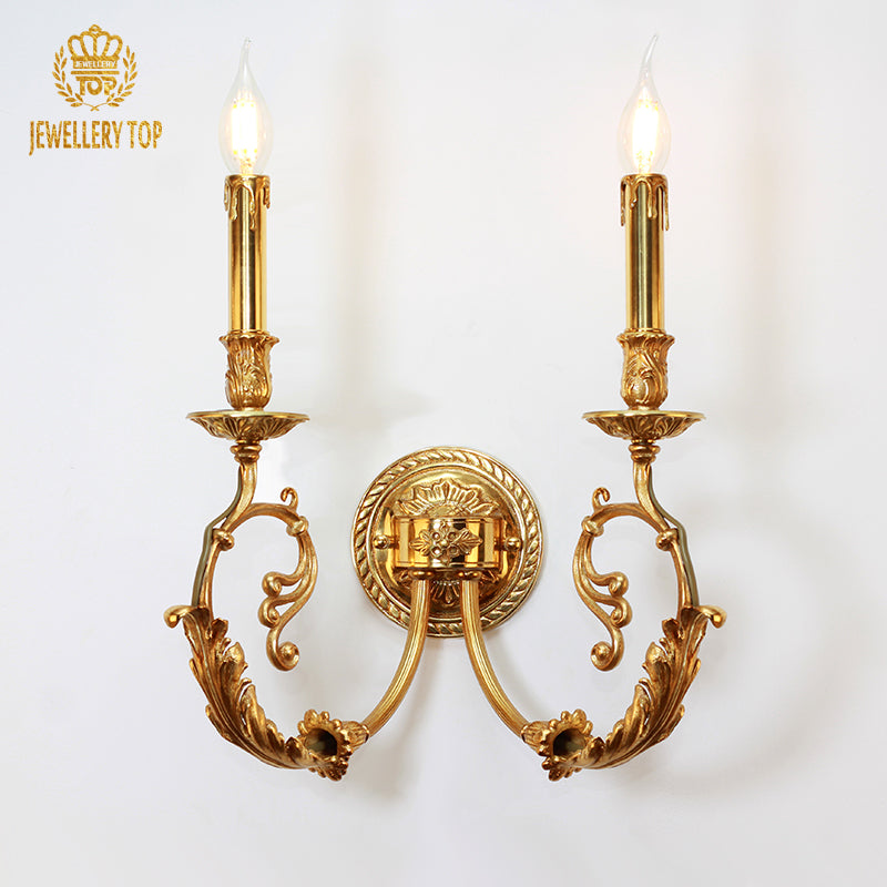 JEWELLERY TOP branded close-up of the luxury brass wall lamp, highlighting its symmetrical arms and ornate central medallion.