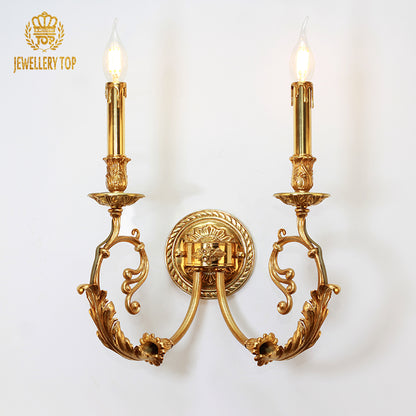 JEWELLERY TOP branded close-up of the luxury brass wall lamp, highlighting its symmetrical arms and ornate central medallion.