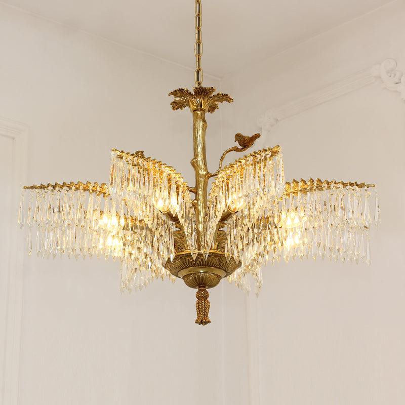 Warm glow from a multi-arm brass chandelier with crystal fringes on white background.