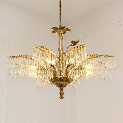 Warm glow from a multi-arm brass chandelier with crystal fringes on white background.