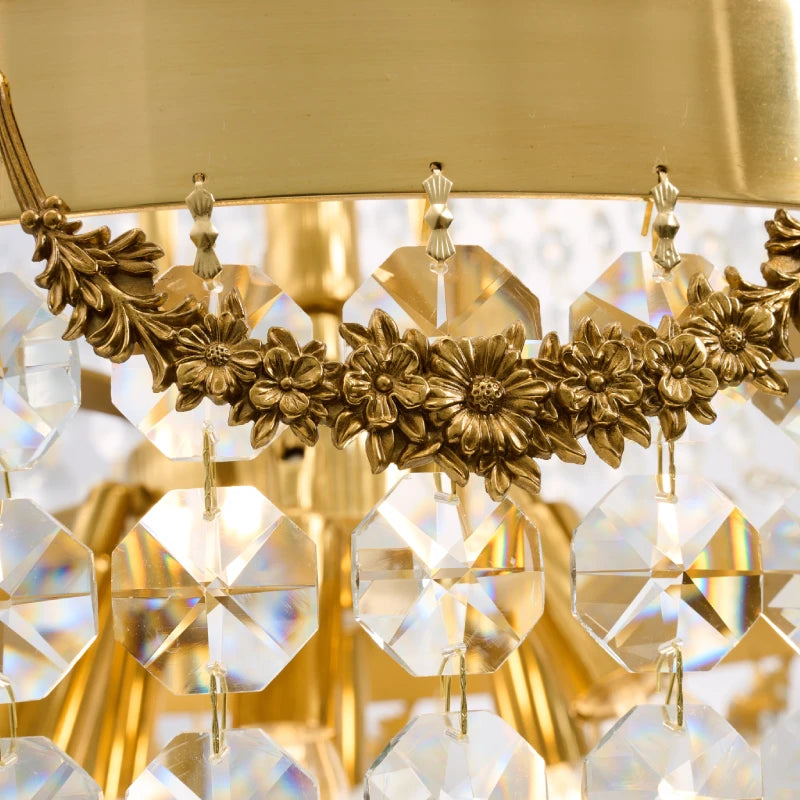 Close-up of intricate brass floral and hanging crystal prisms on a luxury chandelier.
