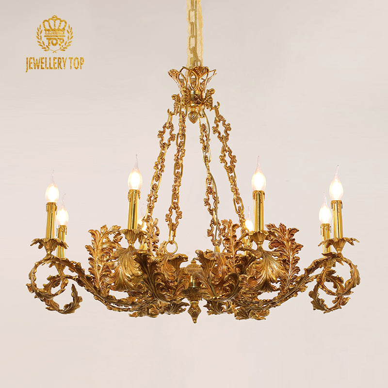 Golden decorative brass chandelier with intricate details against a light wall, brand JEWELLERY TOP.
