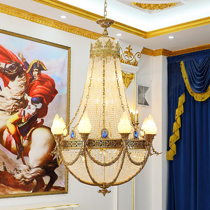 A luxury crystal chandelier installed in a grand hotel corridor with opulent wall moldings and heavy drapery.