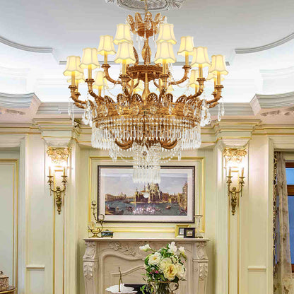 French brass fabric lampshade chandelier installed in an elegant room with green walls and a fireplace.