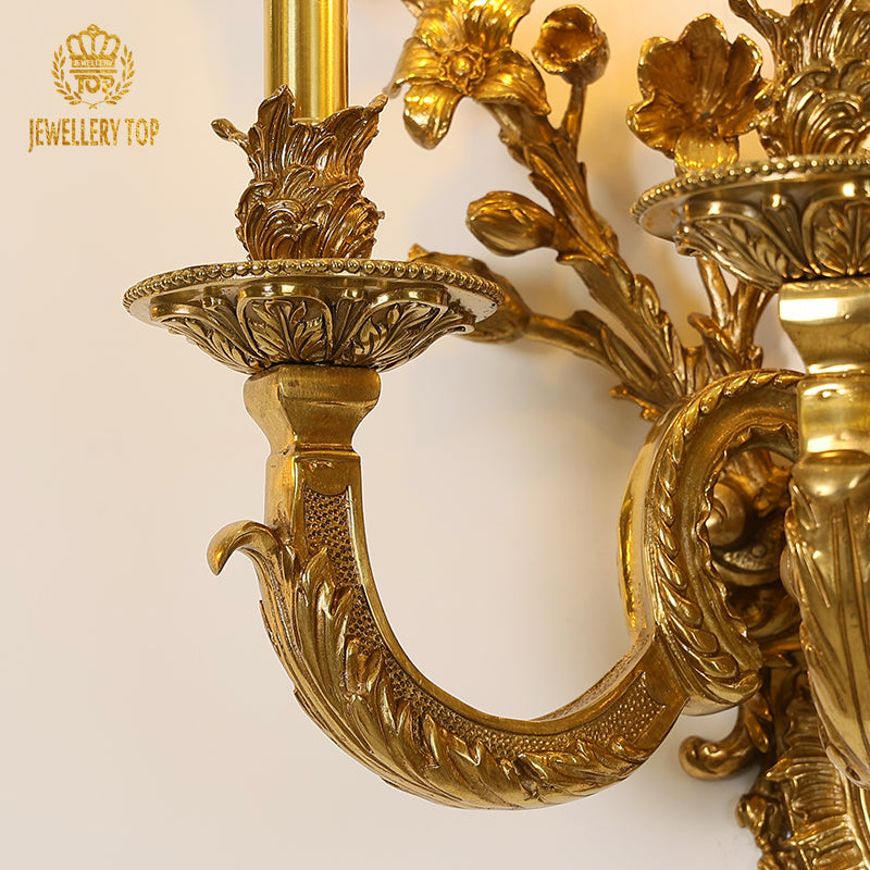 Focused shot on the wall lamp’s finely engraved floral patterns and polished brass surface texture.