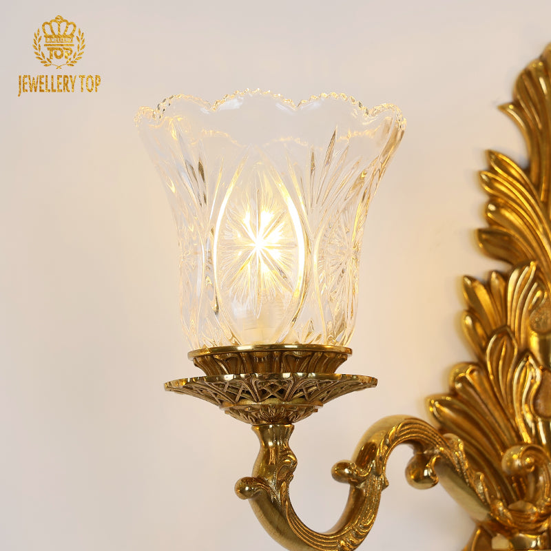 Macro detail of a single fluted glass trumpet shade with its cut-glass texture and glowing candle-style bulb.