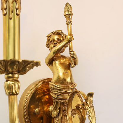 Macro extreme close-up of the cherub sculpture holding a torch, highlighting the intricate golden brass details and texture.