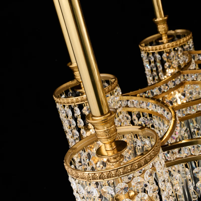 Detailed view of engraved brass columns and crystal clusters on an EGLIGHT luxury chandelier.