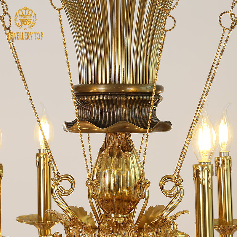 Extreme close-up of intricate brass filigree and candle bulbs on the vintage chandelier's arm.
