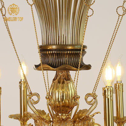 Extreme close-up of intricate brass filigree and candle bulbs on the vintage chandelier's arm.
