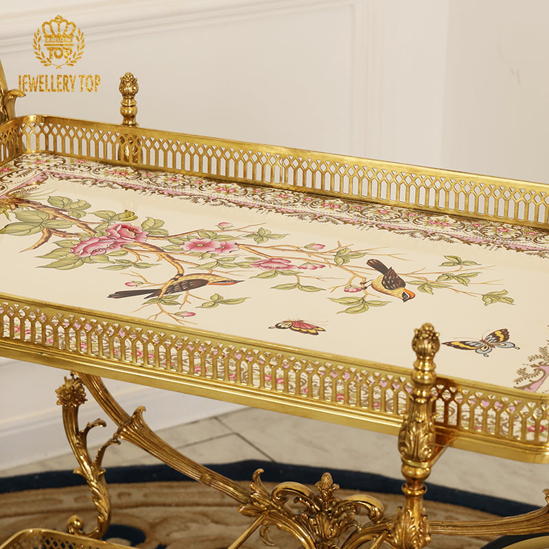 Close-up of the upper ceramic tray detailing hand-painted birds and floral artwork surrounded by a brass gallery by Jewellery Top.
